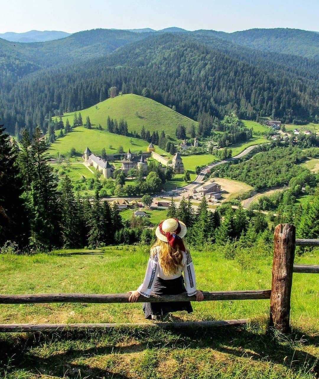 Photo of landscape depicting a girl in traditional clothing that is mesmerised by the beauty of the landscape